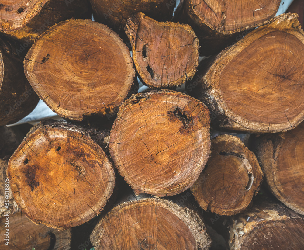 Wooden natural sawn logs background. Stacked wood pine timber. Stack of logs natural wooden background Wooden natural sawn logs background. Stacked wood pine timber. Stack of logs natural wooden background