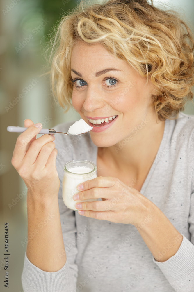 a young woman eating yogurt
