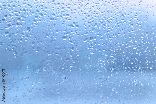 Rain drops on clean blue window glass