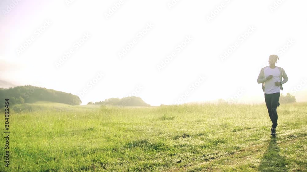 Young mixed race man running on meadow outdoors in nature. Young mixed race man running on meadow outdoors in nature.