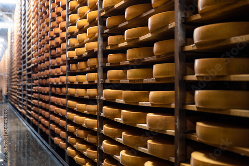 Cheese factory warehouse with shelves stacked with rows of cheese.