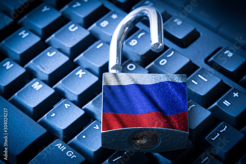 Cyber security concept open padlock on the computer keyboard with russian flag.