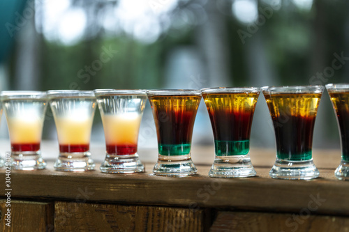 Shot drinks in row. Alcoholic shots on a wooden counter.