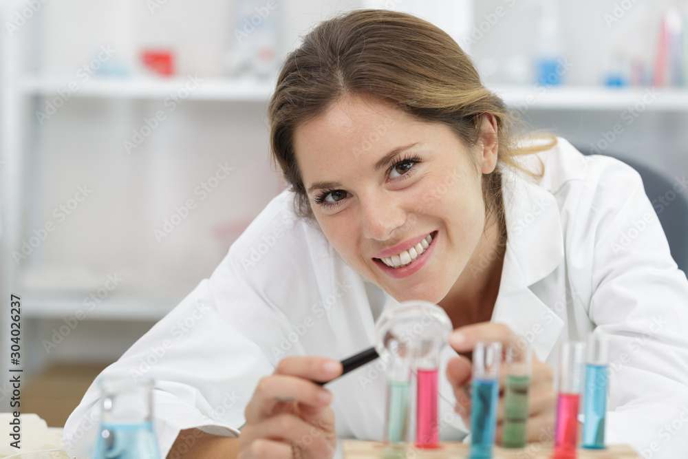 happy woman is looking in a magnifying glass laboratory happy woman is looking in a magnifying glass laboratory