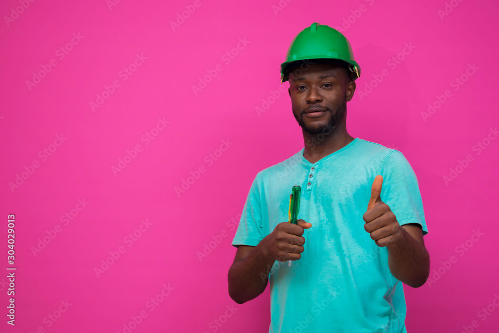 a young african engineer feels happy about his profession and holds a screwdriver a young african engineer feels happy about his profession and holds a screwdriver