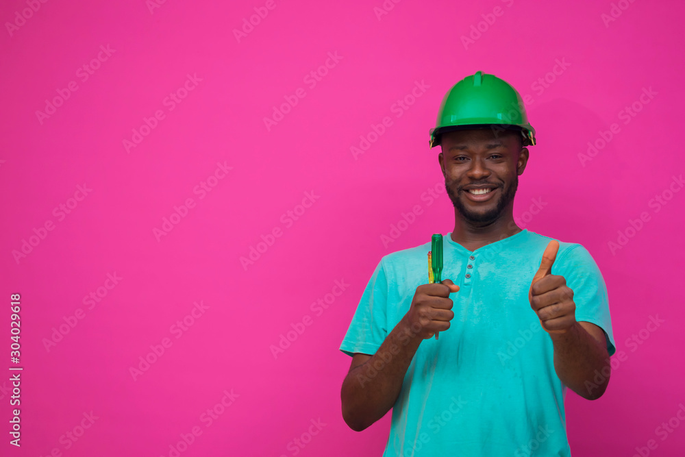 a young african engineer feels happy about his profession and holds a screwdriver a young african engineer feels happy about his profession and holds a screwdriver