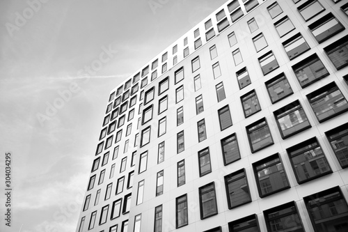 Modern European building. White building with many windows against the blue sky. Abstract architecture, fragment of modern urban geometry. Black and white.