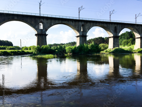 Stone bridge across the river on a sunny day © alipko