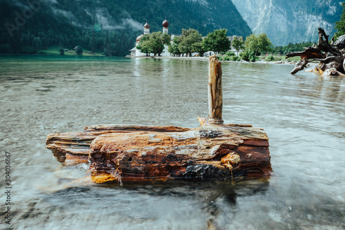 A piece of wood in the Königssee in front of the St. Bartholomew's church in Bavaria, Germany