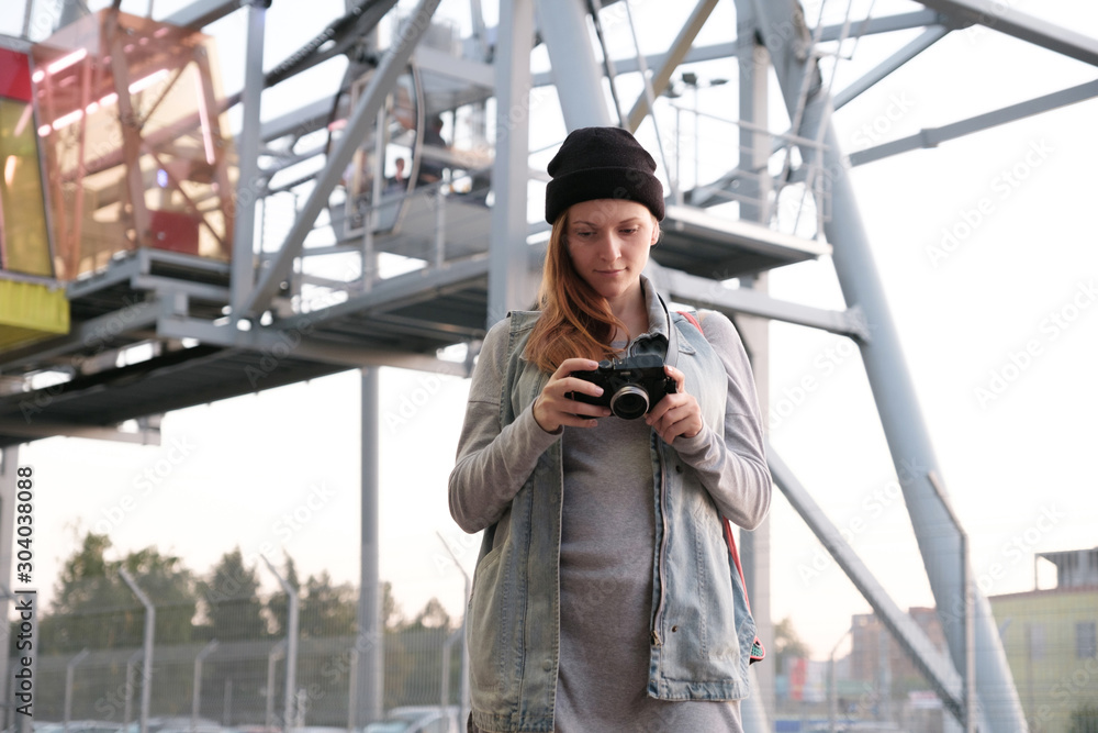 Smiling female photographer checking camera outdoor