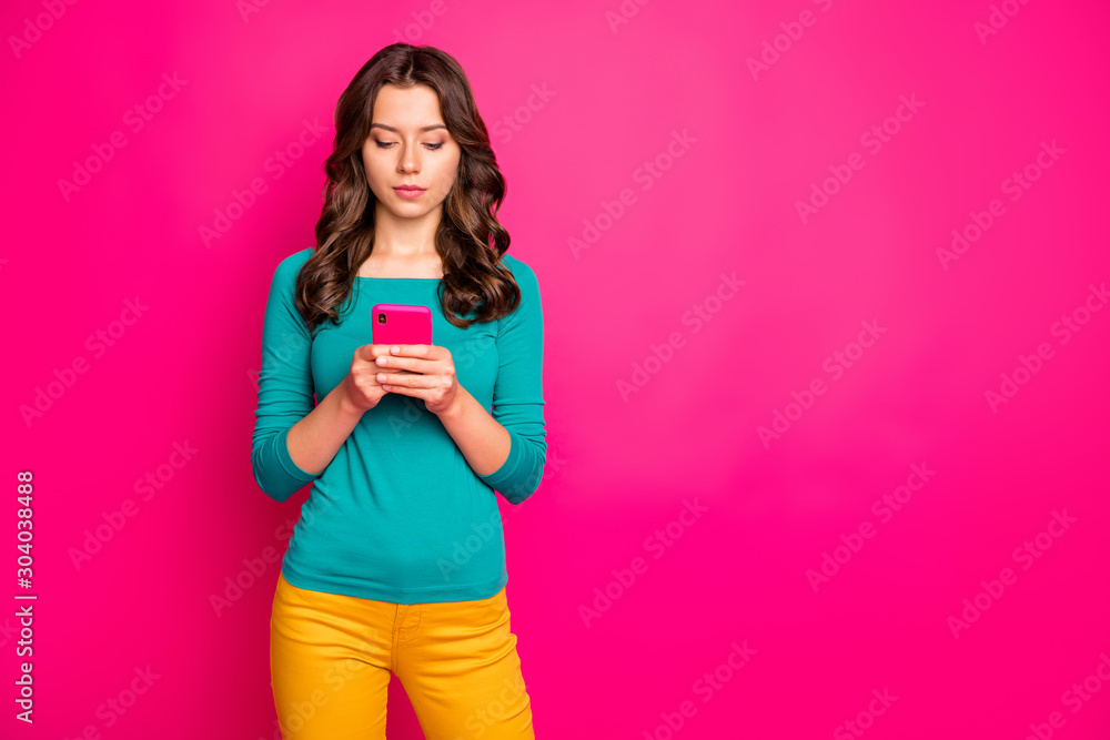 Naklejka premium Photo of pondering pensive thoughtful girl reading feedback left by subscribers analyzing found information with serious facial expression holding telephone isolated vibrant color background
