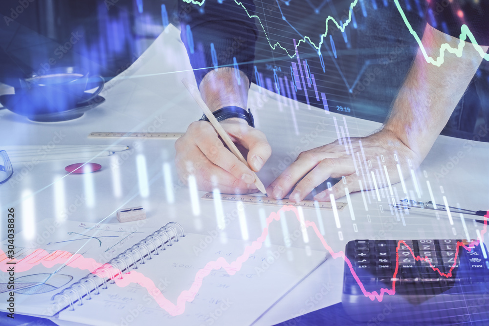 Double exposure of man writing on paper with forex graph. Double exposure of man writing on paper with forex graph.