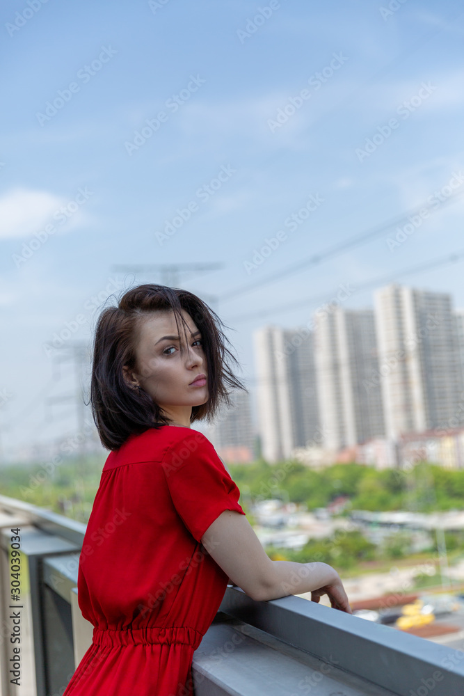 girl in a red dress on the roof overlooking the city