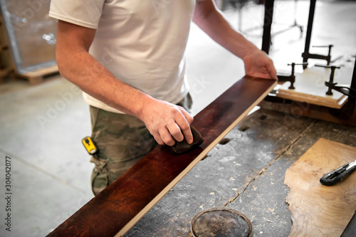 Foto Carpenter or woodworker staining briar root sheet