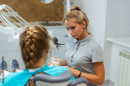 A beautiful girl dentist is receiving a patient