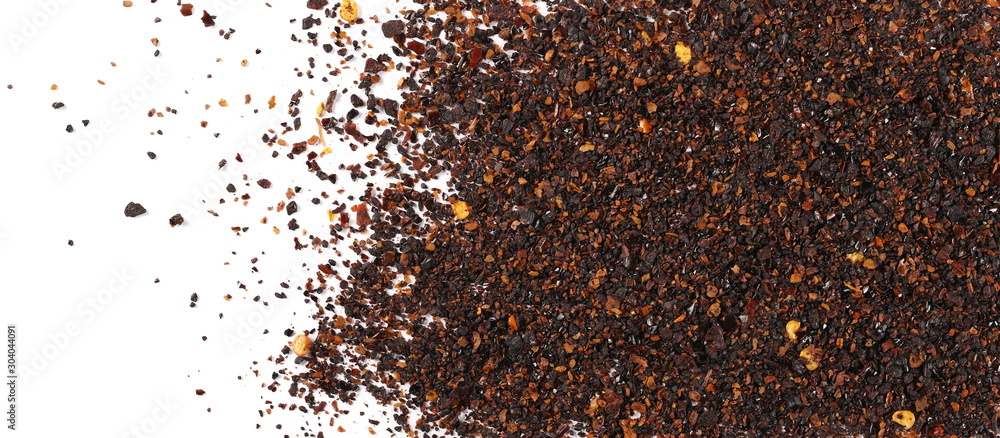 Dry red chili pepper flakes, cut up paprika pile isolated on white background, top view Dry red chili pepper flakes, cut up paprika pile isolated on white background, top view
