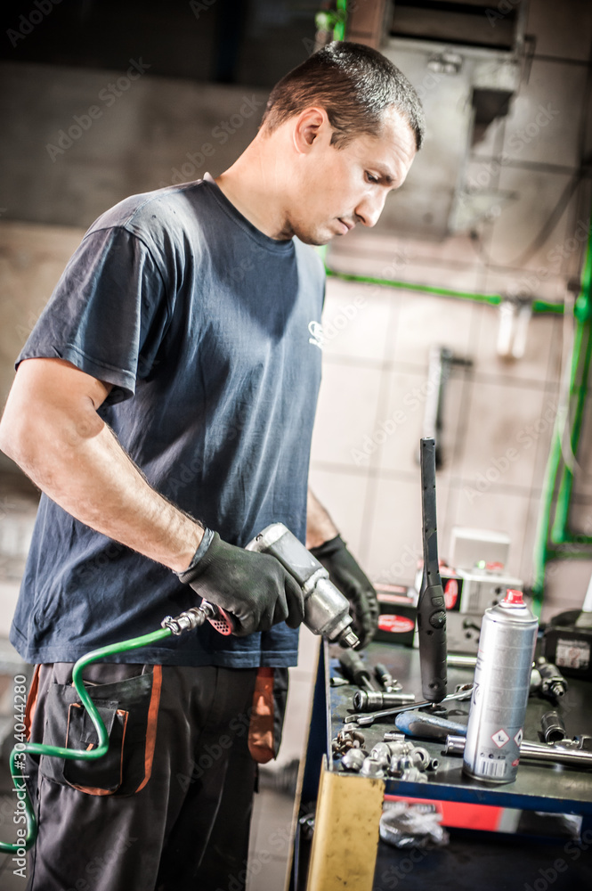 Car mechanic working in auto vulcanizing and vehicle service workshop Car mechanic working in auto vulcanizing and vehicle service workshop