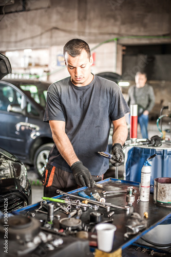 Car mechanic working in auto vulcanizing and vehicle service workshop