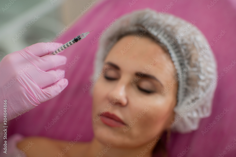 Doctor's hand with a syringe on the background of the patient Doctor's hand with a syringe on the background of the patient
