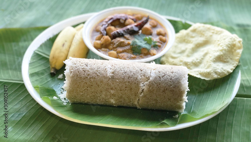Popular South Indian breakfast Puttu or Pittu made of steamed rice flour and grated coconut in the bamboo mould with banana Kerala, India. Sri lankan food - Image photo