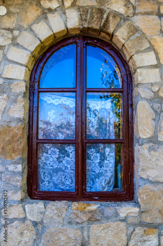 Arched wooden window in a stone wall