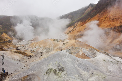 Obraz na płótnie 北海道登別市の登別地獄谷。噴気孔から立ち上る白い湯煙と、荒涼とした火口跡の景観。