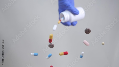 Different types pills falling on transparent surface.  Medicine, drugs, pills, capsules falling in slow motion.