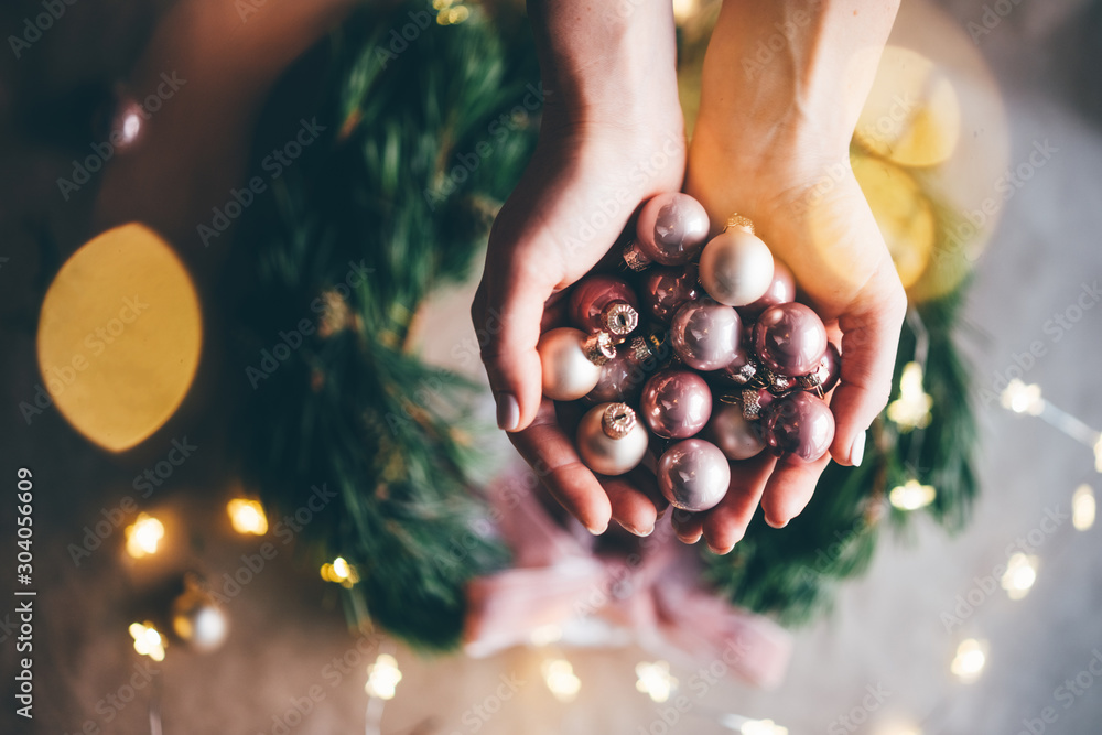 Girl making a handmade christmas wreath. Idea for the festive decoration of the interior. Christmas mood. Close up hand with christmas ball. - obrazy, fototapety, plakaty 