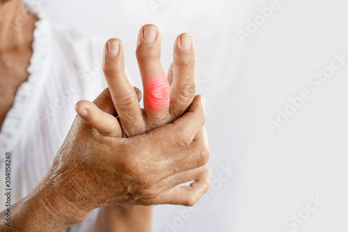 Asian woman hand suffering from joint pain with gout in finger photo
