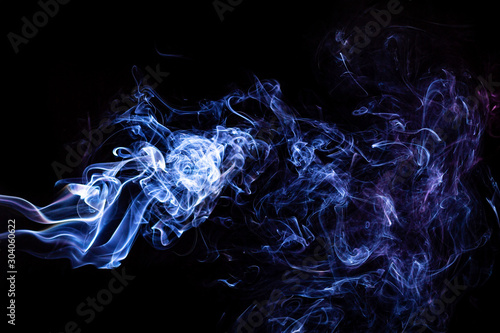 Dym  na czarnym tle.  Fantastyczne kształty z dymu. Błękitne smugi.