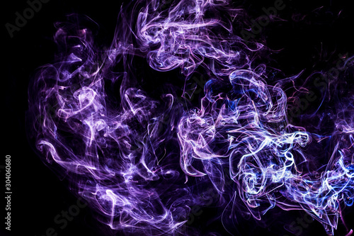 Dym tworzący abstrakcyjne kolorowe kształty na czarnym tle. Przepływ i ruch energii abstrakcyjny obraz.