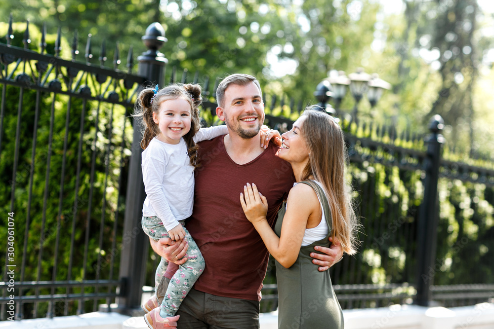 Fototapeta premium Young family with daughter have fun outside in the park.