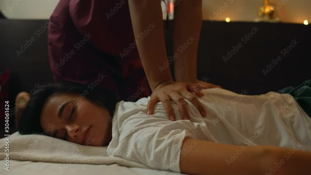 Thai massage. The asian woman rubbed by traditional chiropractor on his back with the hands to relieve tension or pain. Thai massage. The asian woman rubbed by traditional chiropractor on his back with the hands to relieve tension or pain.