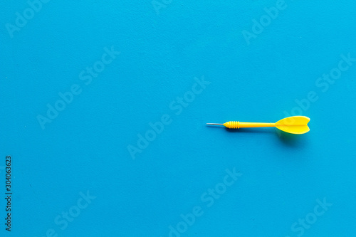 Plastic dart or arrows for darts game on blue background top view copy space