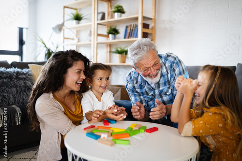 Happy family having fun time at home. Grandparent playing with children