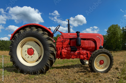 Red vintage tractor in the meadow
