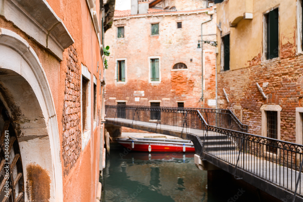 09.10.2019 Venice, Italy, City canal with moored motor boats and gondola.