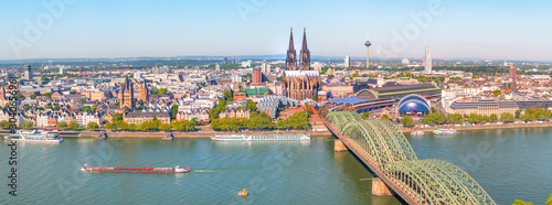 Aerial panorama of the Hohenzollern bridge over Rhine river on a sunny day. Beautiful cityscape of Cologne, Germany  with cathedral and Great St. Martin Church in the background