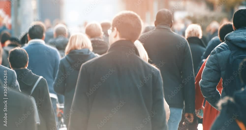 Commuters walking to work with morning sun light in business district, footage of blurred people commuting in downtown from back, busy city life, 4K video