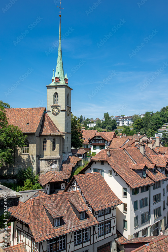 Fototapeta premium Nydegg Church (Nydeggkirche) and houses with tiled rooftops, Bern Switzerland