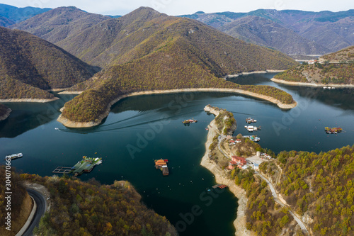 Blue vucha dam in Rhodope mountains during a colorful autumn with some blue clouds in the skies