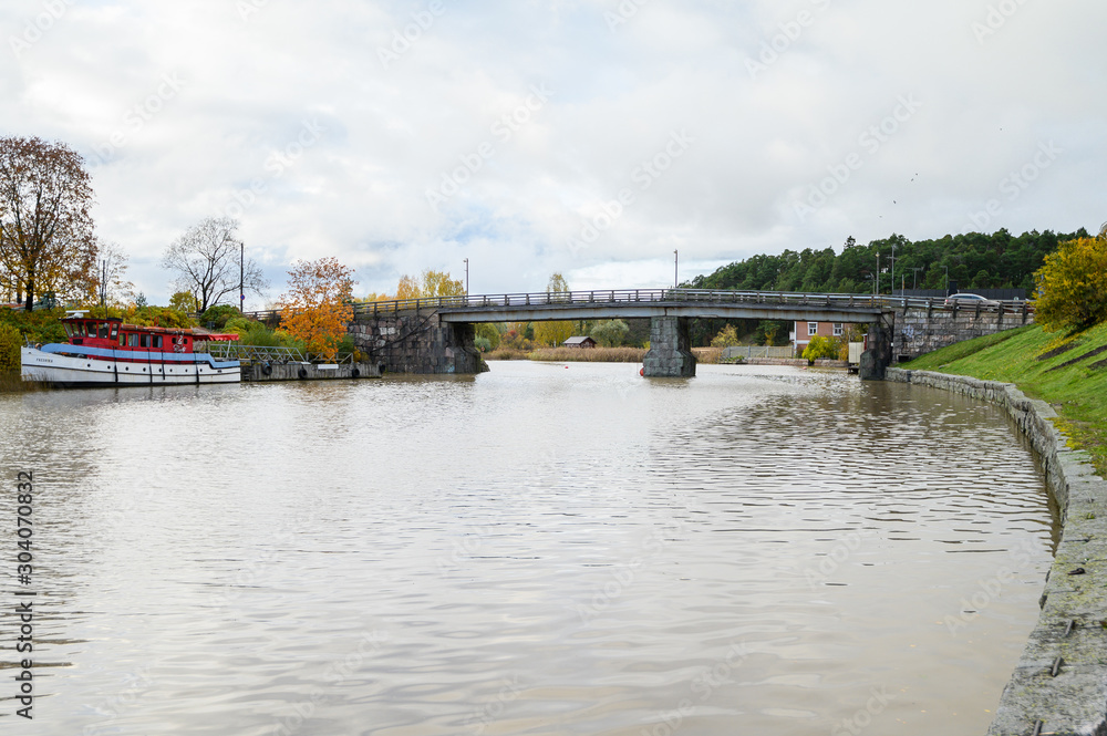 Granite embankment, wooden bridge over the river. Historic centre. Porvoo, Finland