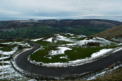 A view of the road across Sheepfold towards Rushup Edge in the Peak District with a covering of snow, from Maam Tor photo