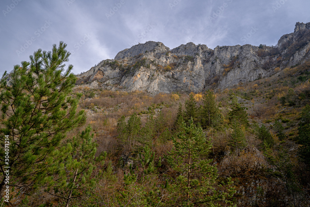 Autumn view towards colorful rocky mountains with blue skies and clouds Autumn view towards colorful rocky mountains with blue skies and clouds
