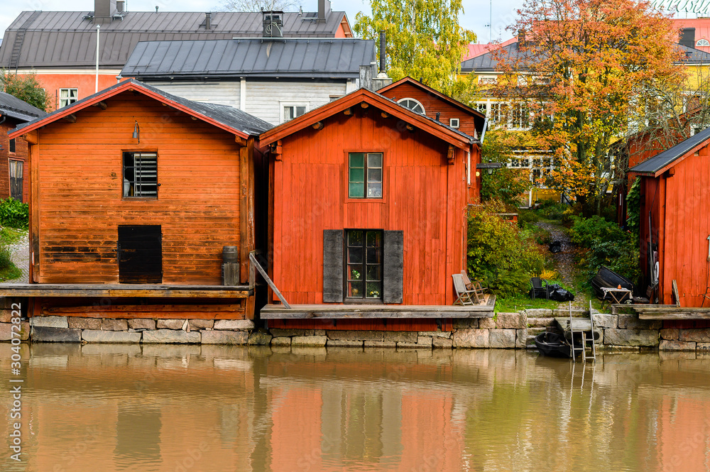 Fototapeta The granite embankment with red houses and barns. Beautiful autumn landscape. Historic centre. Porvoo, Finland