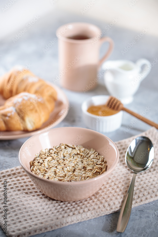 Oatmeal with milk, and croissants with honey on the table. Tasty breakfast. Oatmeal with milk, and croissants with honey on the table. Tasty breakfast.