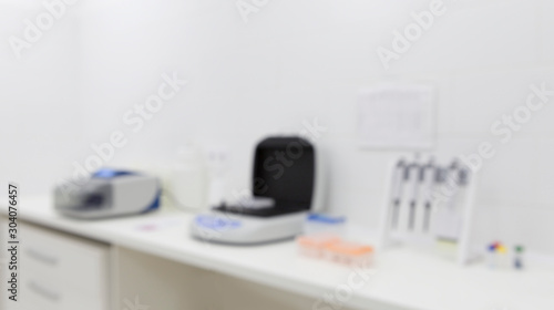 Blurred photo of medical lab equipment on table in light room