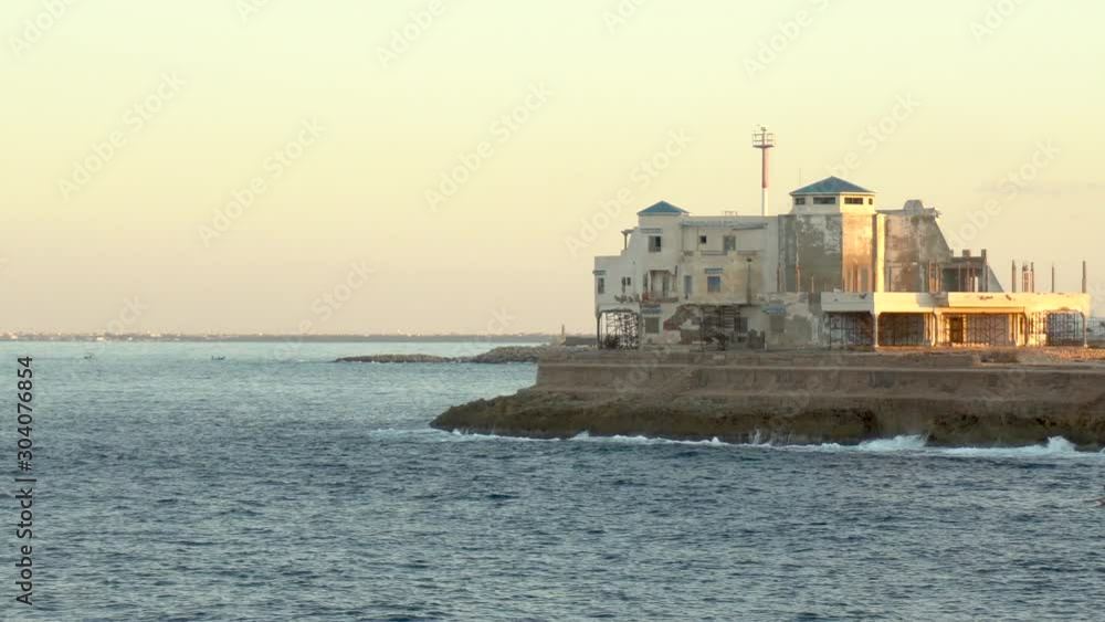 Coast Guard Fortress on a cliff. Large stone building. Around the Mediterranean Sea. The waves hit the rocks Coast Guard Fortress on a cliff. Large stone building. Around the Mediterranean Sea. The waves hit the rocks