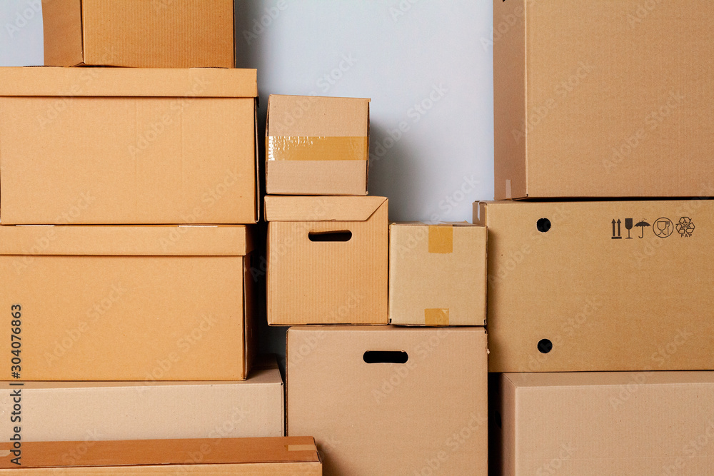Fototapeta premium Cardboard boxes for moving on the floor against grey wall