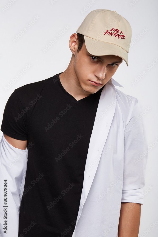 Cropped front view shot of a dark-haired man, wearing beige baseball cap with lettering Cropped front view shot of a dark-haired man, wearing beige baseball cap with lettering